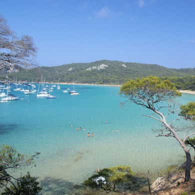 Plage de Porquerolles avec mer turquoise et bateaux au mouillage
