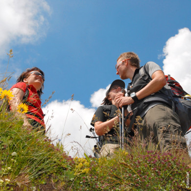 Groupe de randonneurs en été discutant sur un sentier de montagne