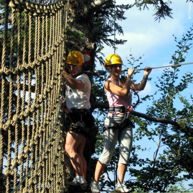 Vacanciers équipés de casques participant à un parcours accrobranche