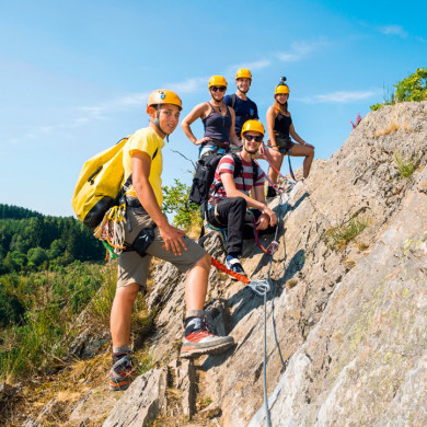 Groupe de vacanciers pratiquant la via ferrata en montagne