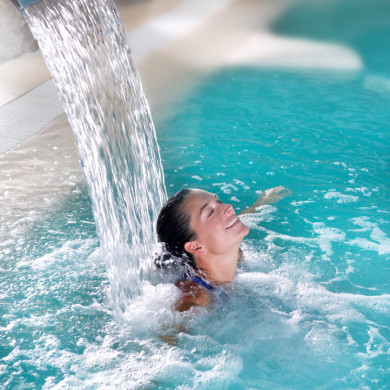 Femme profitant d’un massage d’eau dans une piscine spa