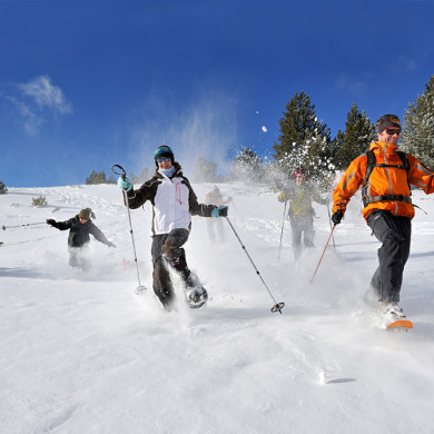 Groupe de vacanciers en randonnée raquettes dans la neige