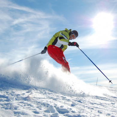 Skieur en pleine descente rapide sur une piste enneigée