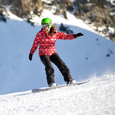 Snowboardeuse dévalant les pistes enneigées de La Mongie dans les Pyrénées
