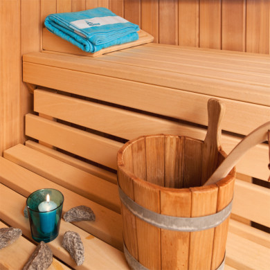 Espace sauna avec seau en bois et serviette pour un moment de détente à Metabief
