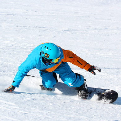 Snowboardeur en descente sur les pistes enneigées des Menuires, résidence Azureva