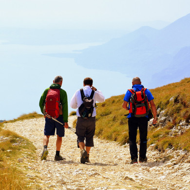 Vacanciers en randonnée estivale dans les Alpes avec vue sur le lac et montagnes