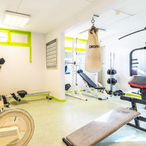 Salle de sport équipée avec appareils de musculation et sac de frappe à Metabief