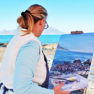 Femme peignant un paysage marin sur chevalet en bord de mer à Hauteville-sur-Mer