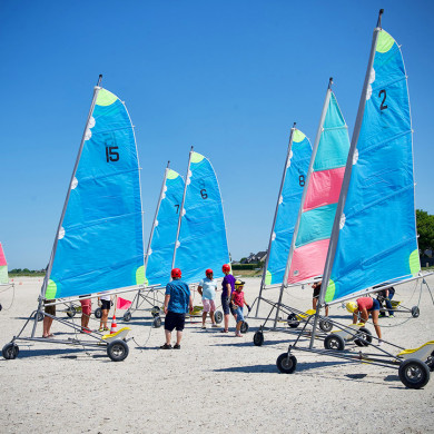 Séance de char à voile sur la plage de Hauteville-sur-Mer avec des voiles colorées