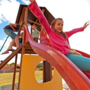 Enfant descendant un toboggan dans une aire de jeux en club de vacances