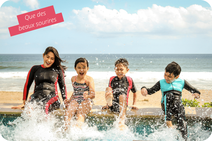Famille et enfants s’amusant au bord de la piscine avec de grands sourires